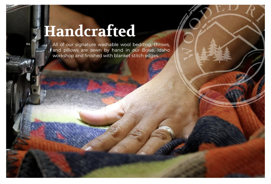 person hand sewing wooded river blanket